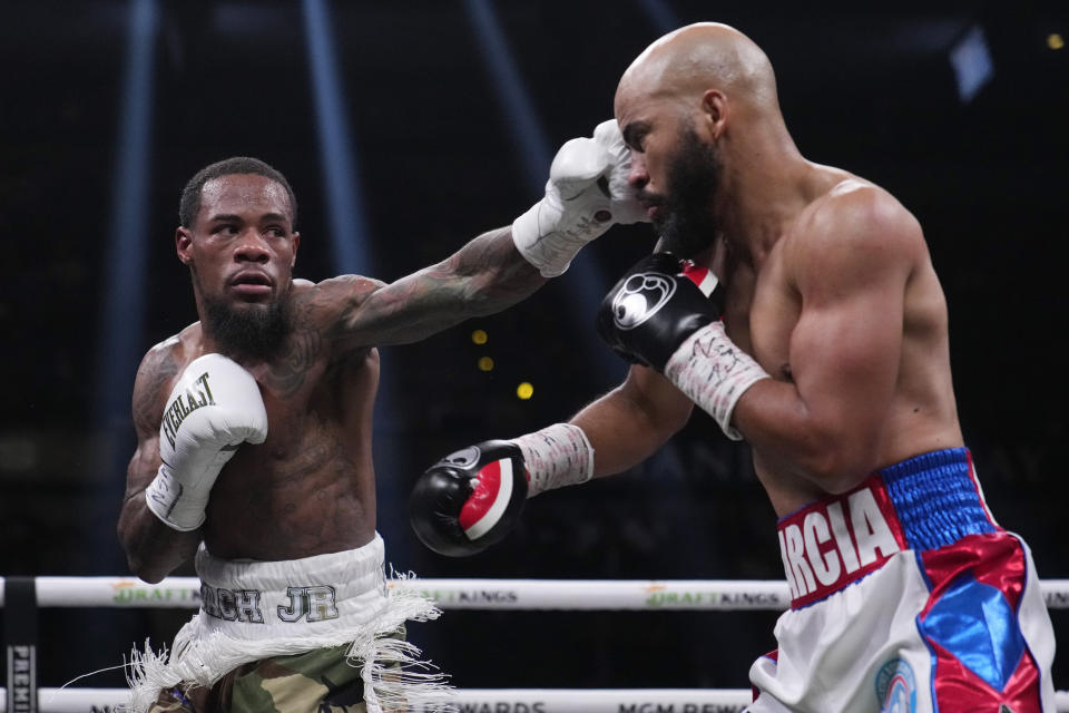 Lamont Roach, left, lands a left on Hector Garcia, right, in a super featherweight championship boxing match Saturday, Nov. 25, 2023, in Las Vegas. (AP Photo/John Locher)
