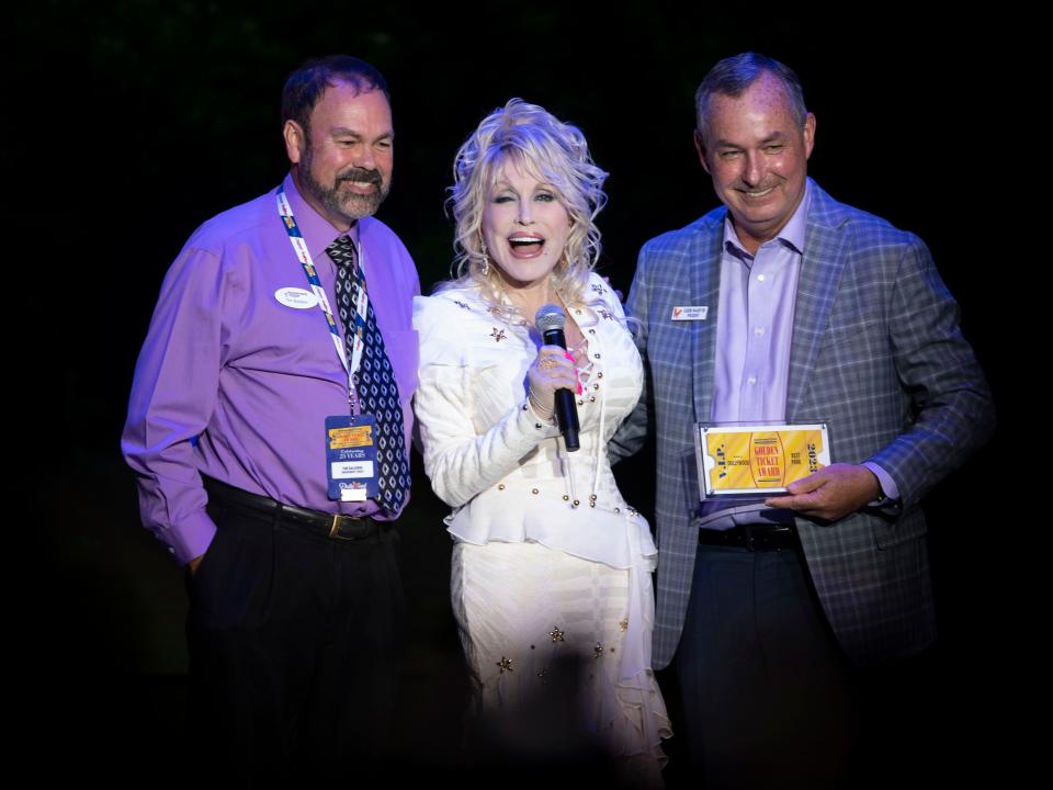 Dolly Parton surprises guests with an appearance as Dollywood President Eugene Naughton, right, is presented with the Golden Ticket Award by Amusement Today's Tim Baldwin naming Dollywood as Park of the Year during an awards ceremony at Dollywood on Saturday, September 9, 2023 in Pigeon Forge, Tenn.