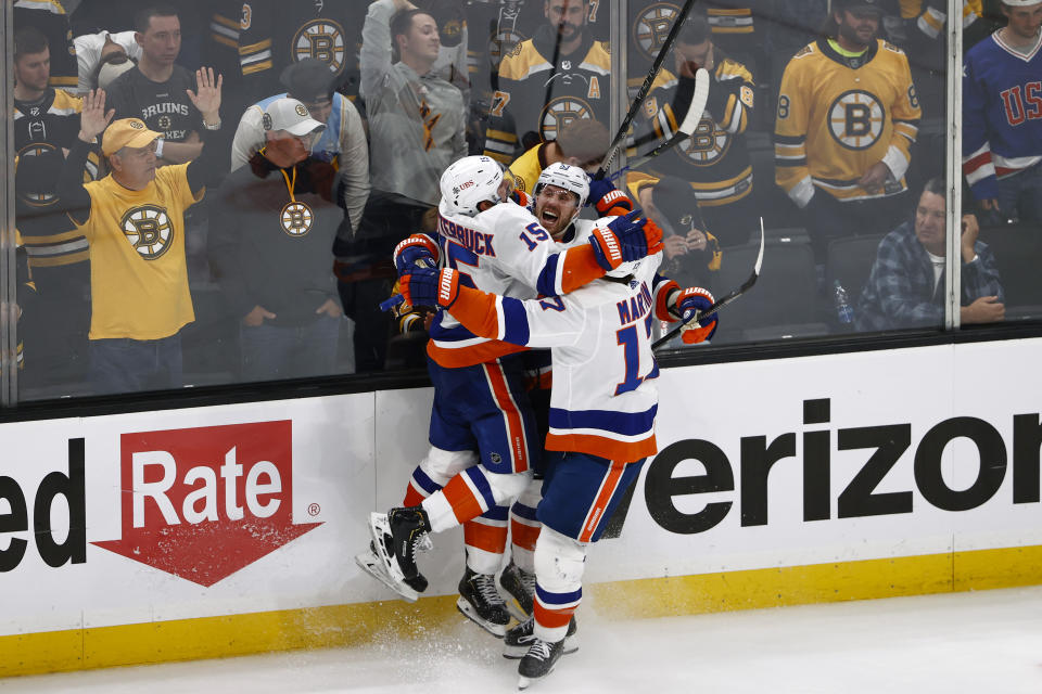 As Boston Bruins fans look on, New York Islanders' Casey Cizikas celebrates his winning goal in overtime with teammates Matt Martin (17) and Cal Clutterbuck (15) during Game 2 of an NHL hockey second-round playoff series , Monday, May 31, 2021, in Boston. (AP Photo/Winslow Townson)