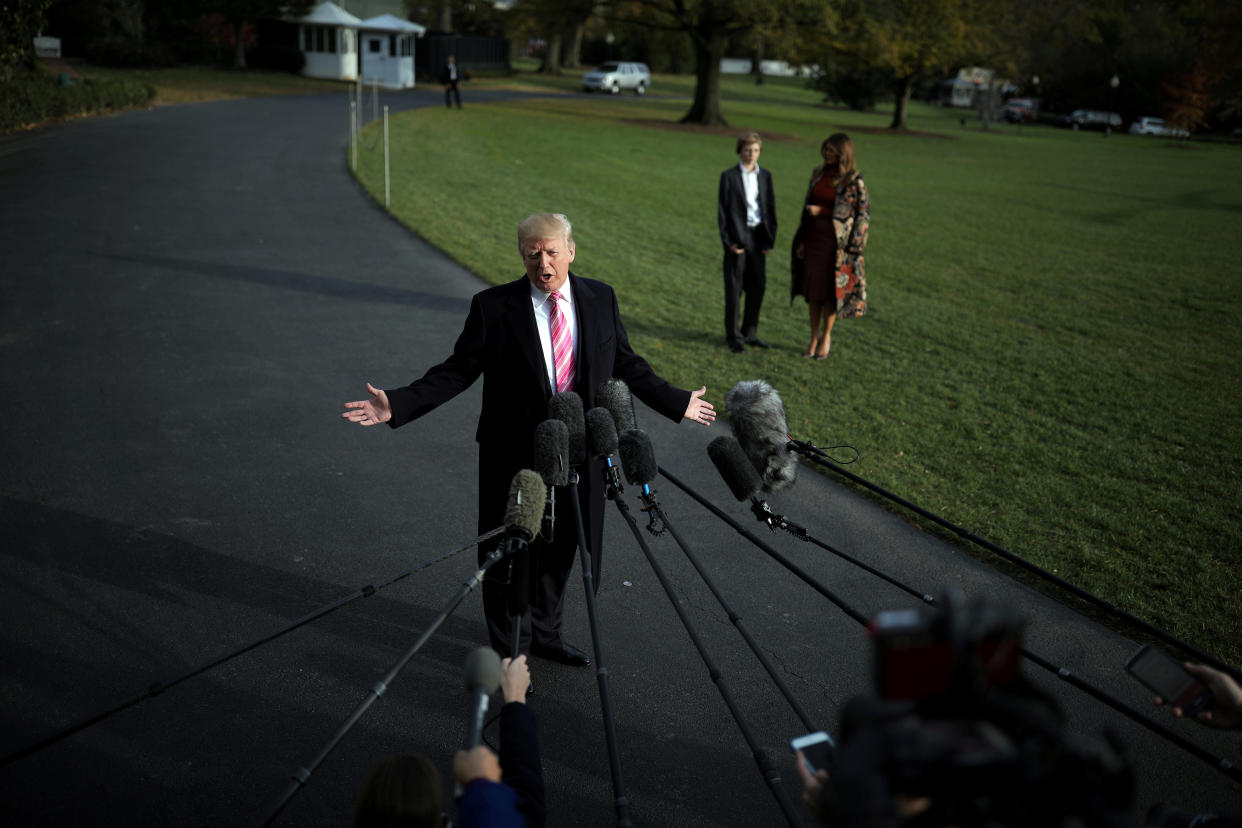 President Trump talks with the reporters as first lady Melania Trump and their son Barron wait for him before departing the White House for Palm Beach, Fla., on Nov. 21. (Carlos Barria/Reuters)