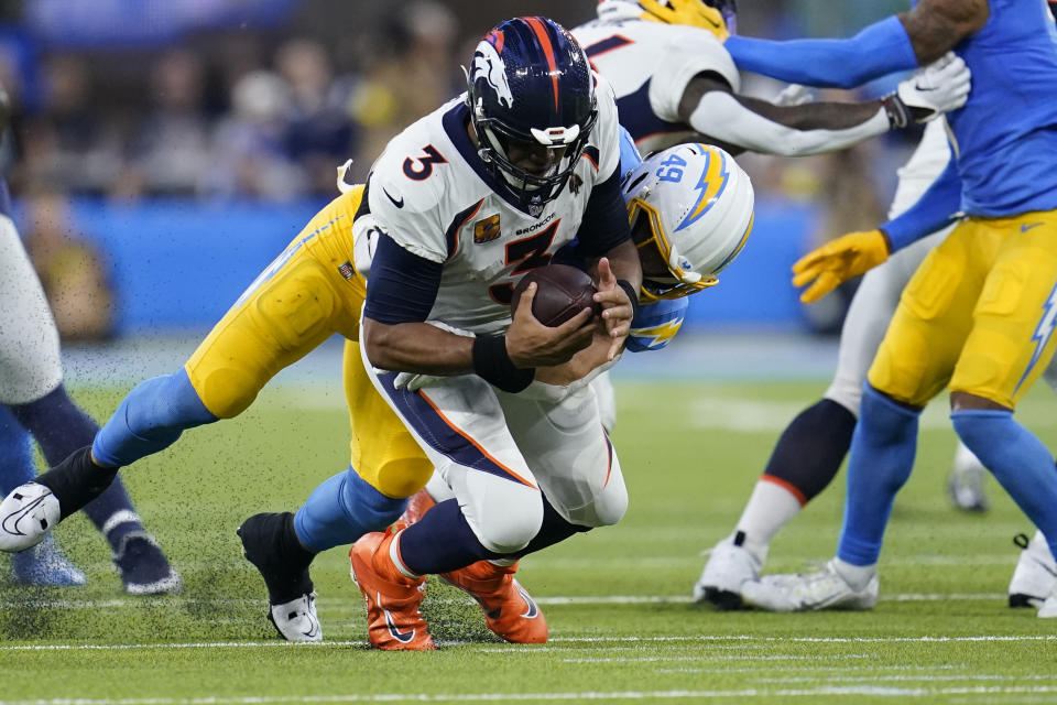Los Angeles Chargers linebacker Drue Tranquill (49) sacks Denver Broncos quarterback Russell Wilson (3) during the second half of an NFL football game, Monday, Oct. 17, 2022, in Inglewood, Calif. (AP Photo/Marcio Jose Sanchez)