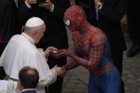 Pope Francis meets Spider-Man, who presents him with his mask, at the end of his weekly general audience with a limited number of faithful in the San Damaso Courtyard at the Vatican, Wednesday, June 23, 2021. The masked man works with sick children in hospitals. (AP Photo/Andrew Medichini)