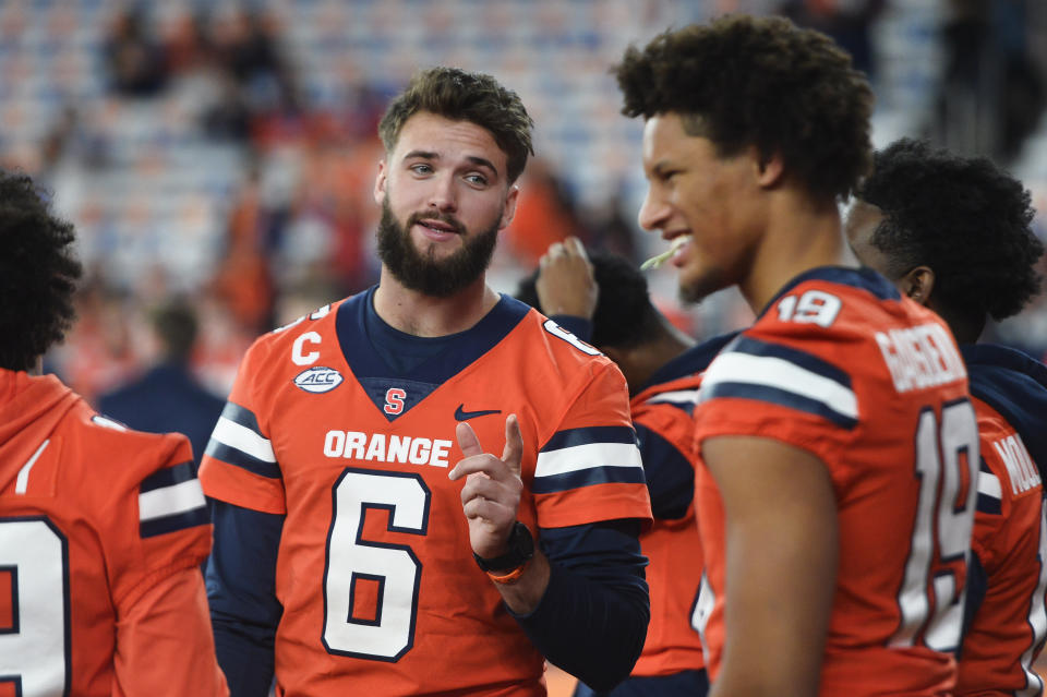 Syracuse quarterback Garrett Shrader (6) talks with tight end Oronde Gadsden II as players warm up for an NCAA college football game against Boston College in Syracuse, N.Y., Friday, Nov. 3, 2023. (AP Photo/Adrian Kraus)