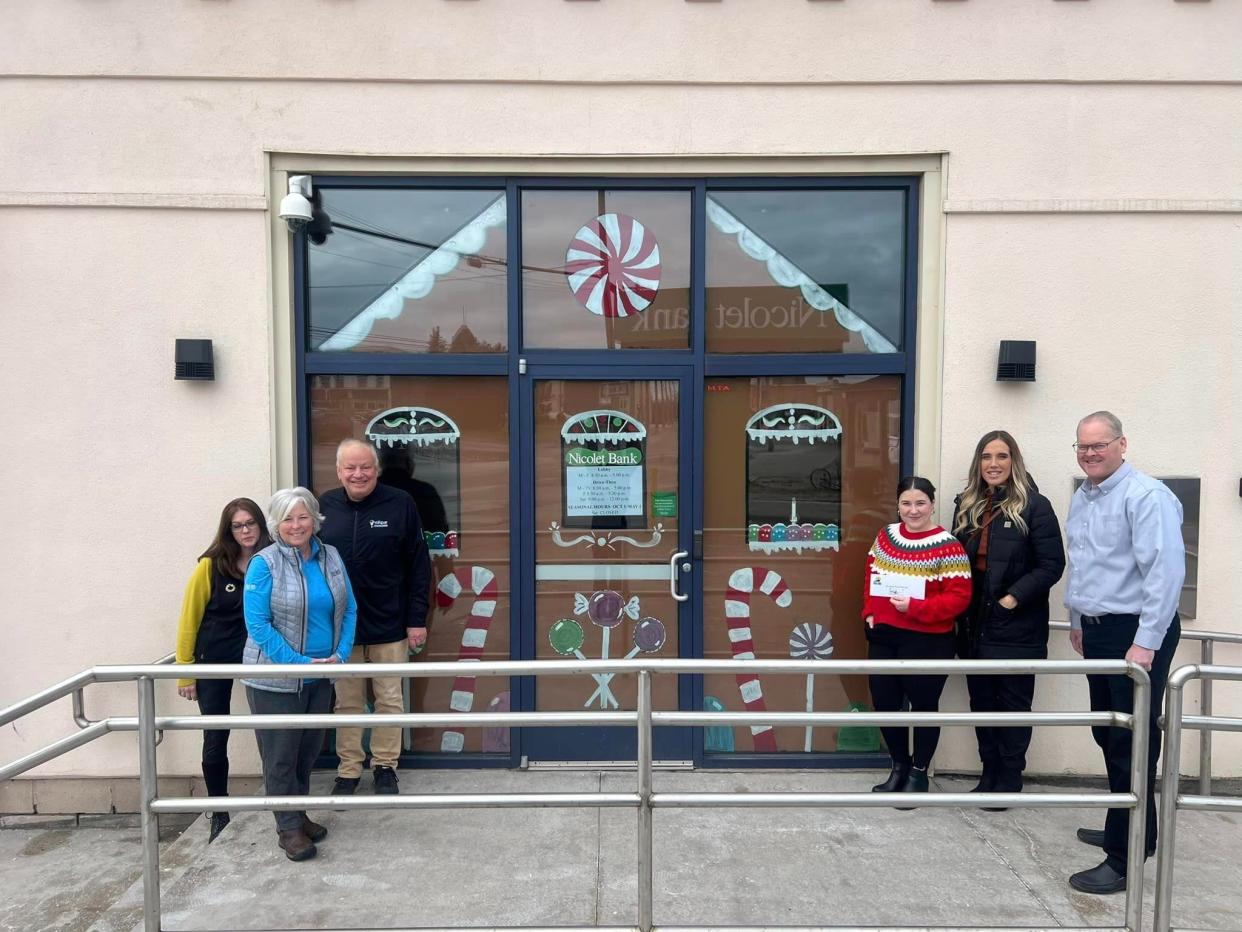 Chamber of Commerce Director Tony Haller and DDA Director Stephanie Sprecker announce Nicolet Bank as one of the winners of the second annual downtown business Christmas decoration contest.