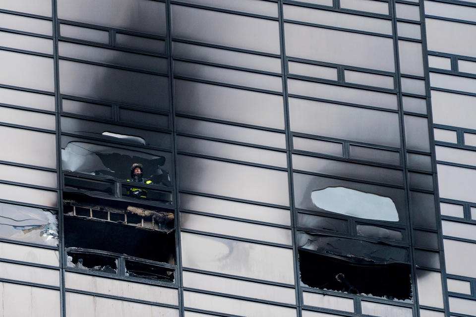 <p>A firefighter looks out from the window of a damaged apartment in Trump Tower in New York on Saturday, April 7, 2018. (Photo: Craig Ruttle/AP) </p>