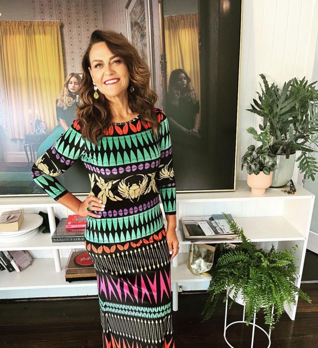 Chrissie Swan smiles for the camera in a bold printed dress.