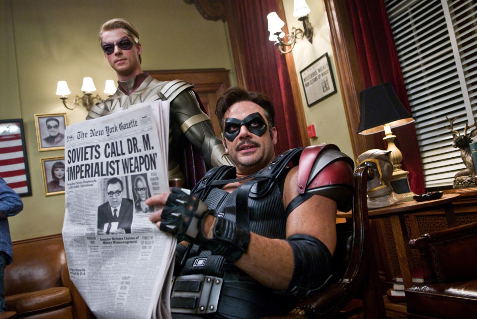 Matthew Goode looks annoyed while Jeffrey Dean Morgan reads a newspaper.