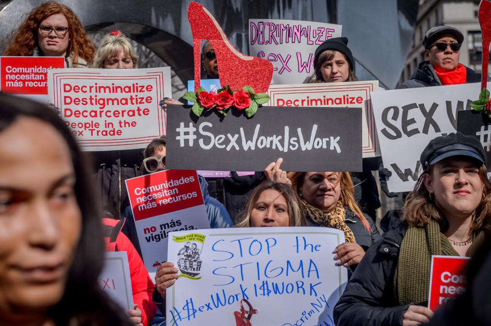 Protestors holding signs in support of decriminalizing sex work