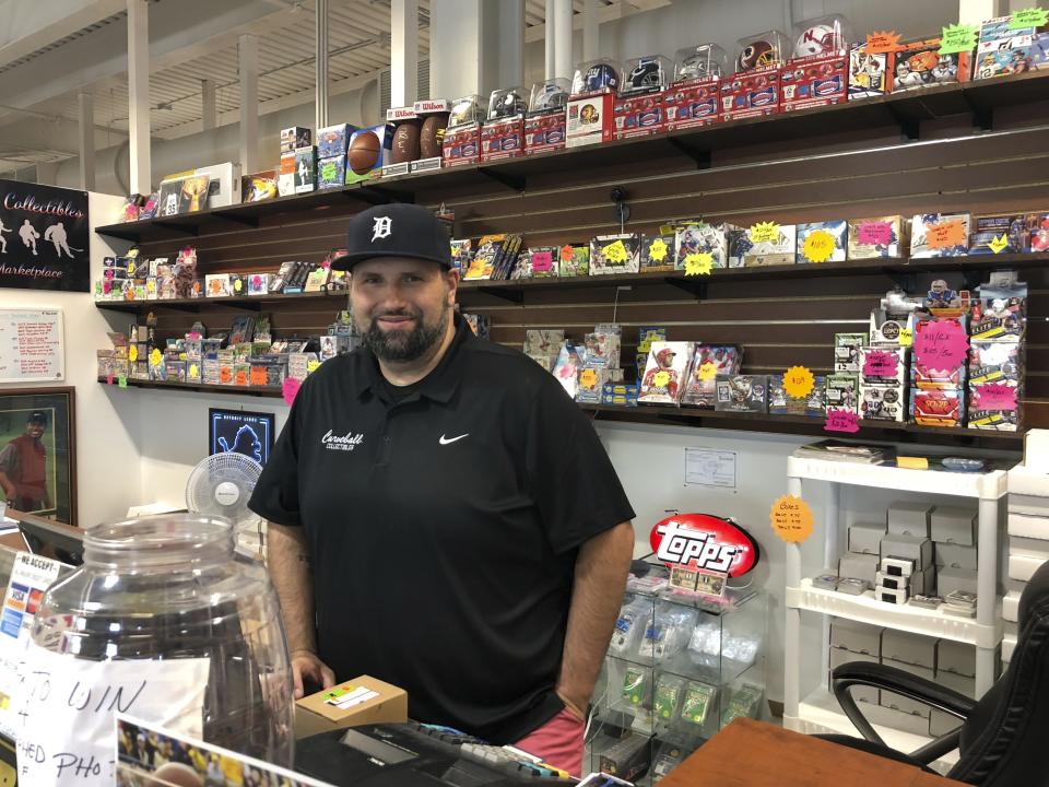 In this July 17, 2019 photo, Mike Wilson, who runs Curveball Sportscards and Collectibles at the SVRC Marketplace in downtown Saginaw, Michigan works in his store. He supports President Donald Trump and credits him for a good economy. Economic conditions in Michigan could be crucial in determining whether Democrats retake a state they once held for decades (AP Photo/Sara Burnett)