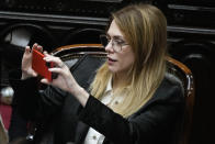 Pro-government lawmaker Lilia Lemoine holds her cell phone during the debate on a bill promoted by Argentine President Javier Milei that includes a broad range of economic, administrative, criminal, and environmental reforms, at Congress in Buenos Aires, Argentina, Tuesday, April 30, 2024. (AP Photo/Natacha Pisarenko)