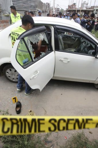 Nepalese crime officers examine the car in which a Supreme Court judge was shot in Kathmandu on Thursday. Judge Rana Bahadur Bam, a Supreme Court justice for four years, had been suspended from hearing cases after being accused of taking bribes in return for giving lenient sentences to criminals