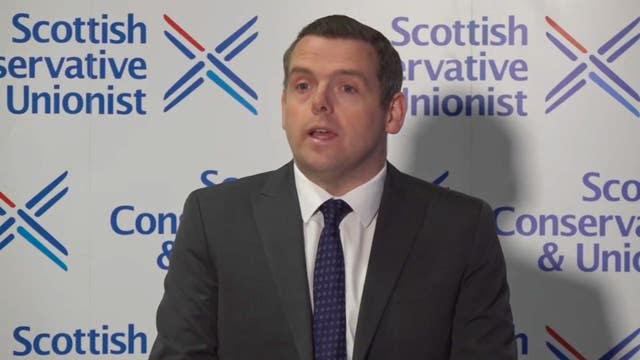 Douglas Ross speaking in front of a Scottish Conservatives backdropp
