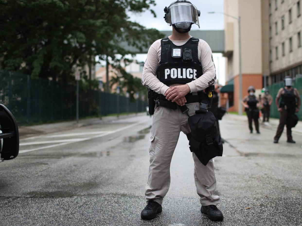 Miami-Dade police officers watch as demonstrators walk past during a protest against police brutality and the recent death of George Floyd on June 02, 2020 in Miami, Florida. Protests continue to be held in cities throughout the country over the death of George Floyd, who was killed while in police custody in Minneapolis on May 25th.