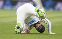 New Zealand's Kane Williamson rolls on the ground after taking a catch to dismiss the West Indies' John Campbell during play on day three of their first cricket test in Hamilton, New Zealand, Saturday, Dec. 5, 2020. (Andrew Cornaga/Photosport via AP)