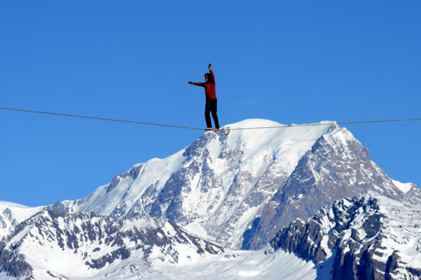 French highliner Julien Millot performs on the Paradiski cable way, 380m high, designed by French creator Jean-Charles de Castelbajac, on December 16, 2013 in front of the Mont Blanc mountain in La Plagne.      AFP PHOTO / JEAN-PIERRE CLATOT        (Photo credit should read JEAN-PIERRE CLATOT/AFP/Getty Images)