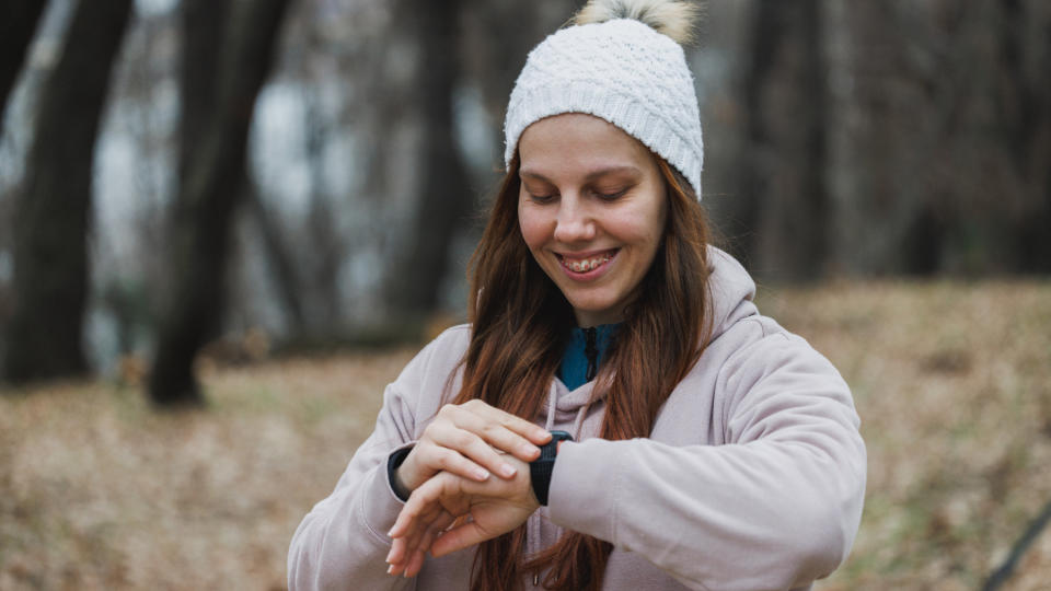 A woman checking her fitness tracker while walking