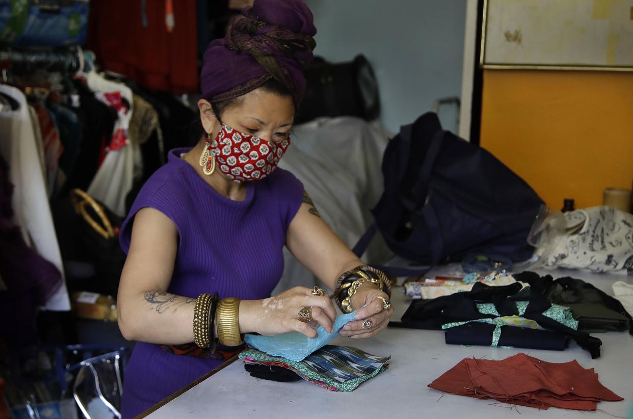 Marie Biscarra, co-owner of ISSO fashion boutique, sorts fabric used to make masks to aid in the prevention of COVID-19 Monday, May 18, 2020, in San Francisco, Calif. A San Francisco Bay Area county that reported the first known death from coronavirus in the U.S. says it will allow some retail businesses to re-open, although it's not known when. Santa Clara County said Monday in a joint statement with four other counties that COVID-19 trends were looking positive enough to allow curbside and storefront shopping. The statement says the trend of new cases and the number of hospitalized patients is stable or declining. San Francisco, Marin and San Mateo counties started allowing some retail sales Monday.