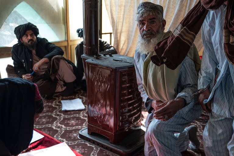 Esta foto tomada el 28 de noviembre de 2022 muestra a un hombre afgano (izquierda), que ha sido condenado a muerte por asesinato, esposado a otro preso durante una audiencia en el Tribunal de Apelaciones de Ghazni, en el este de Afganistán