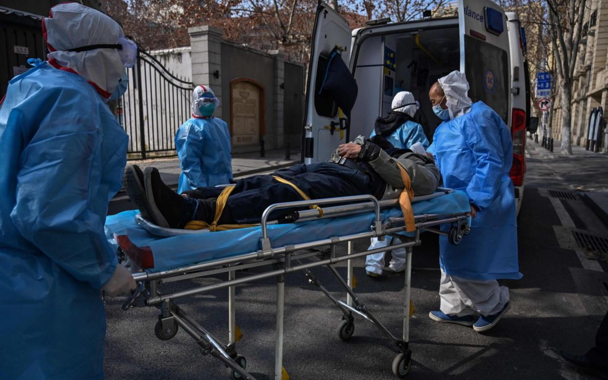 Medical staff in protective clothes carrying a patient - AFP