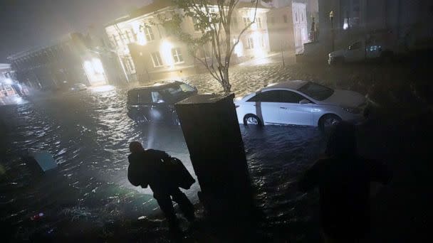 PHOTO:People use flashlights as they walk on flooded streets in search of their vehicle, Sept. 16, 2020, in Pensacola, Fla.  (Gerald Herbert/AP)