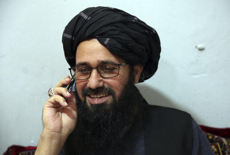 In this Saturday, Dec. 14, 2019, photo, Maulvi Niaz Mohammad, 45, talks on his mobile phone during an interview with The Associated Press inside the Pul-e-Charkhi jail in Kabul, Afghanistan. Mohammad is serving a 15-year jail term. During the Taliban rule he served with Qari Ahmadullah, a Taliban intelligence commander that controlled much of northern Afghanistan. (AP Photo/Rahmat Gul)