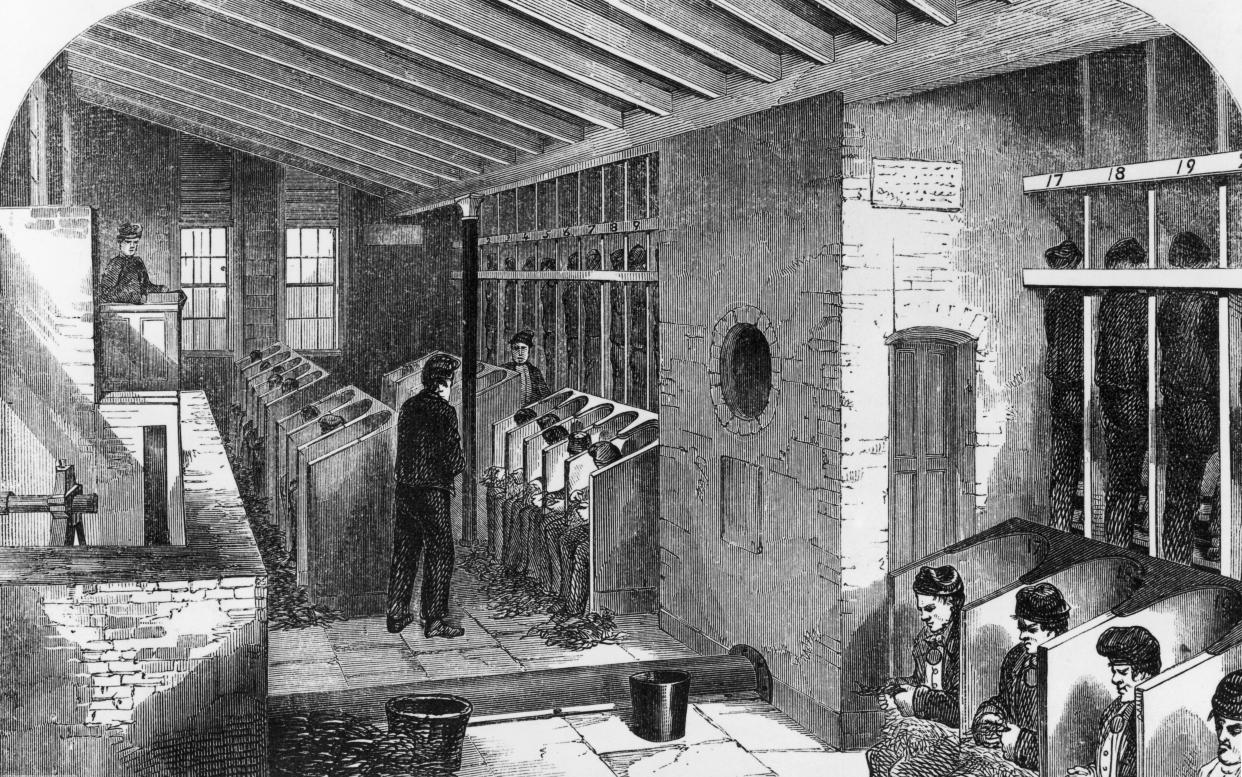 Prisoners on a treadmill (far right) and picking oakum in the oakum shed at Holloway Prison, London, 1862. Oakum picking involves teasing out old tarred rope to be used for caulking ships. (Photo by Hulton Archive/Getty Images)