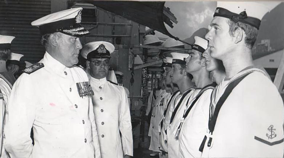 In this image taken in 1971 Lt. Cmdr. Robert Embleton, rear left, on HMS Danae in Singapore presenting his supply and secretariat division to Vice Admiral Sir David Williams, left, during inspection. From resounding applause to ostracization and isolation. That's essentially the journey Lt. Cmdr. Robert Embleton, who served 34 years in Britain's Royal Navy, took by ambulance when discharged from Derriford Hospital in Plymouth, southwest England, on April 8 following his near-month sickness with the coronavirus. (Courtesy of Robert Embleton via AP)