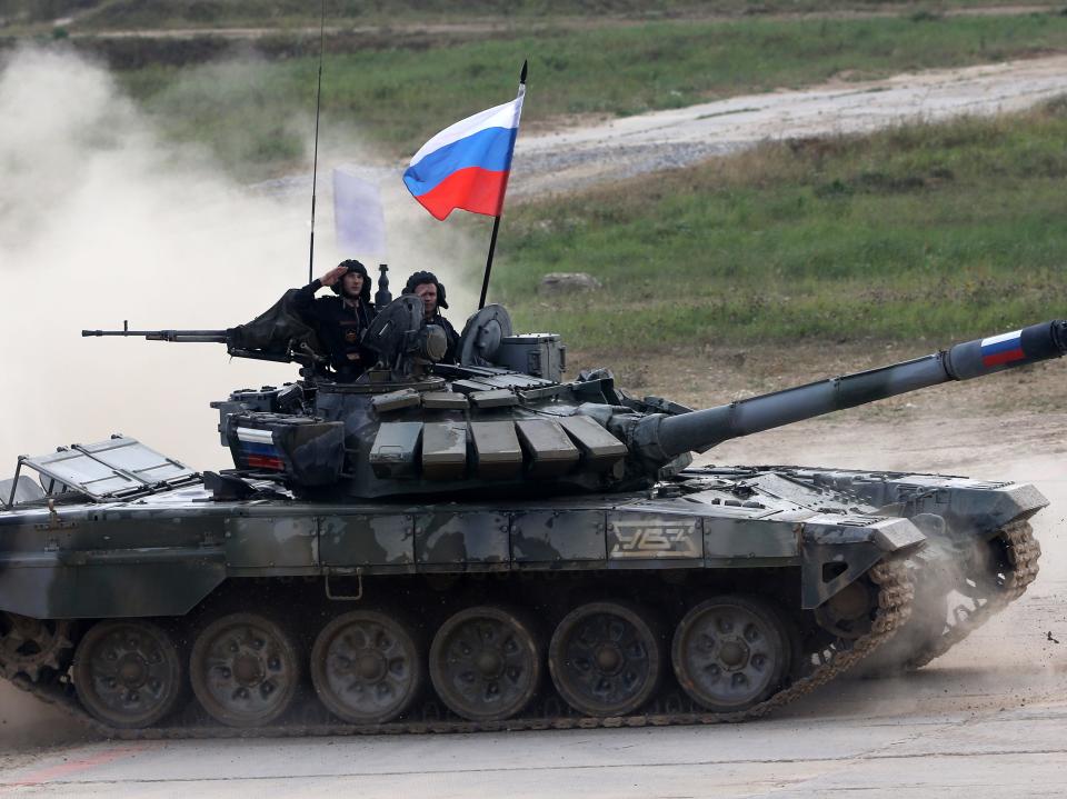 Russian team members on a T-72 B3 battle tank salute during the finals of the tank biathlon at a military polygon, on August 27, 2022, in Alabino, outside of Moscow, Russia.