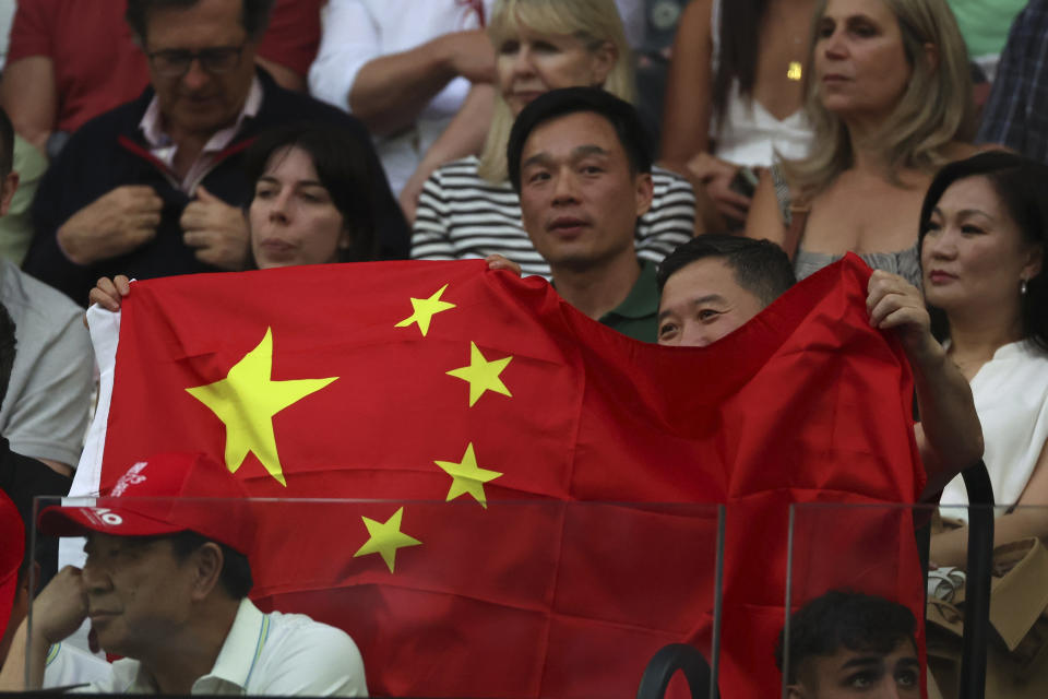 Supporters of Zheng Qinwen of China react as they watch her play Aryna Sabalenka of Belarus in the women's singles final at the Australian Open tennis championships at Melbourne Park, Melbourne, Australia, Saturday, Jan. 27, 2024. (AP Photo/Asanka Brendon Ratnayake)