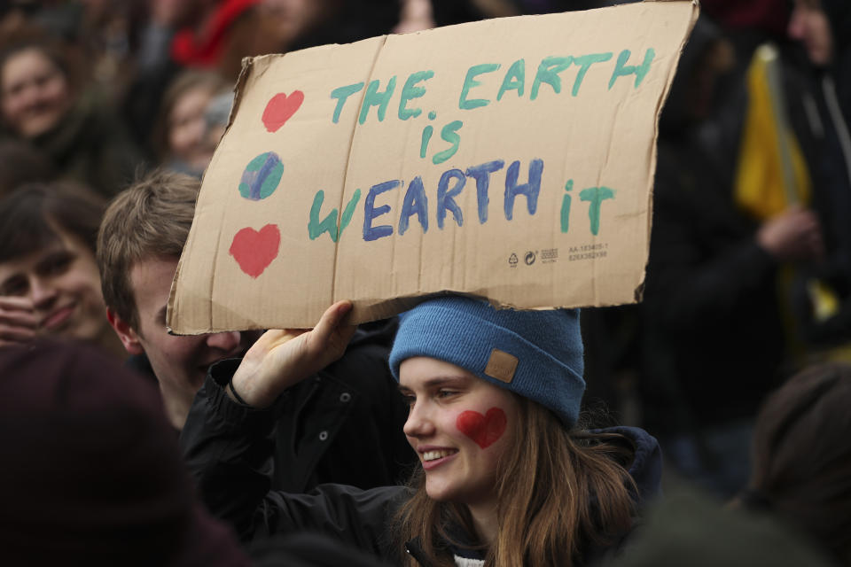 A young woman holds up a board as she marches with others during a climate change protest in Brussels, Thursday, Jan. 31, 2019. Thousands of teenagers in Belgium have skipped school for the fourth week in a row in an attempt to push authorities into providing better protection for the world's climate. (AP Photo/Francisco Seco)