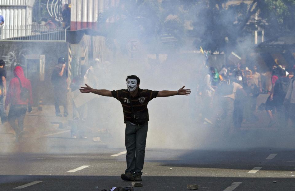 Un manifestante enmascarado abre sus brazos durante una protesta en Caracas contra el gobierno de Venezuela el 20 de marzo de 2014