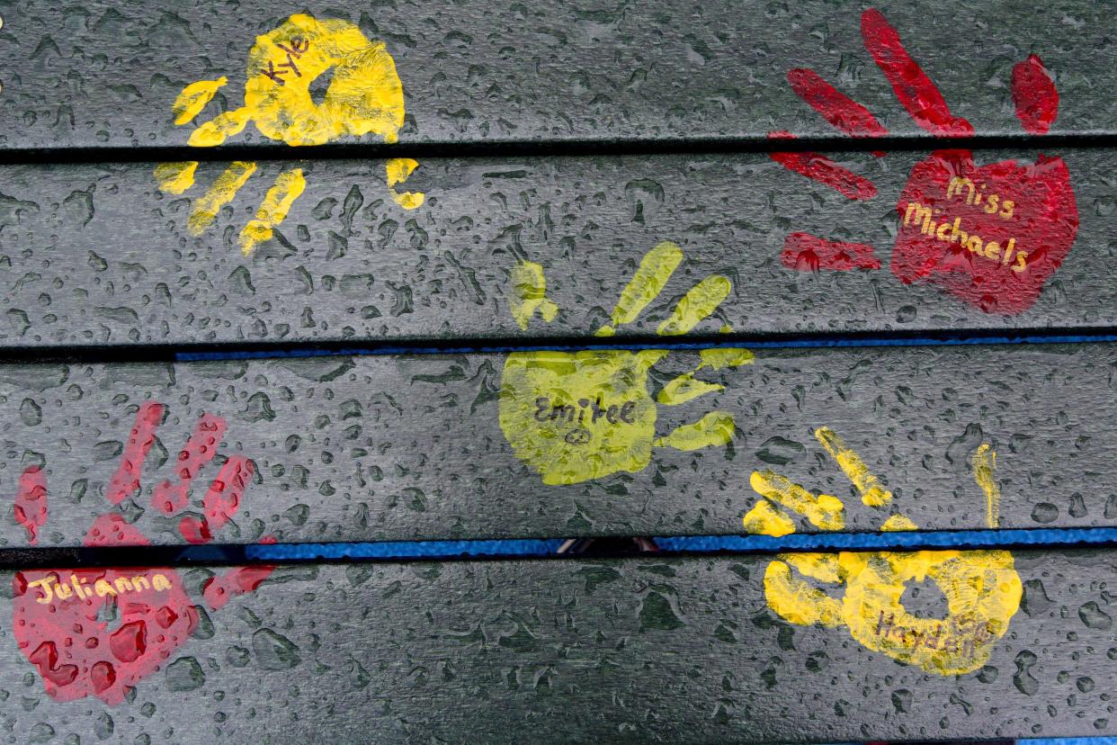 Painted handprints with names of teachers and students are on a playground bench at the new Sandy Hook Elementary School in Newtown, Conn. (Photo: Mark Lennihan/AP)