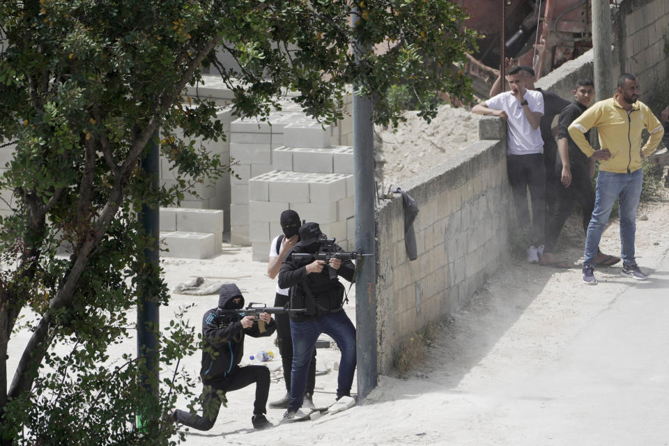 FILE - Palestinian gunmen take aim during an Israeli military operation in the West Bank town of Jenin, Friday, May 13, 2022. Daoud Zubeidi, a Palestinian gunman who is the brother of a prominent jailed Palestinian militant died Sunday after being critically wounded in clashes with Israeli forces, according to the Israeli hospital where he was being treated. (AP Photo/Majdi Mohammed, File)