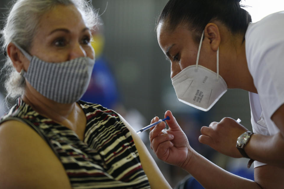 A medical worker injects a woman with a dose of the Russian COVID-19 vaccine Sputnik V at the Palacio de los Deportes, in the Iztacalco borough of Mexico City, Wednesday, Feb. 24, 2021. (AP Photo/Rebecca Blackwell)