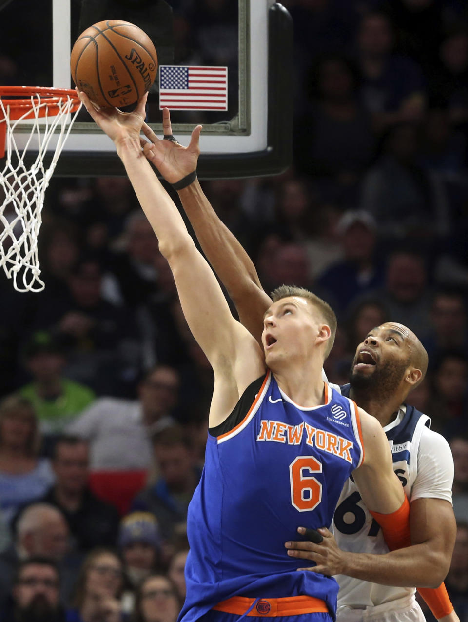 FILE - In this Jan. 12, 2018, file photo, New York Knicks' Kristaps Porzingis, left, of Latvia, outreaches Minnesota Timberwolves' Taj Gibson as he lays up the ball in the first half of an NBA basketball game in Minneapolis. The Knicks agree to trade injured star Kristaps Porzingis to Dallas Mavericks on Thursday, Jan. 31, 2019. (AP Photo/Jim Mone, File)