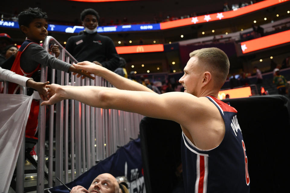 Washington Wizards center Kristaps Porzingis (6) greets fans after the team's NBA basketball game against the Utah Jazz, Saturday, Nov. 12, 2022, in Washington. The Wizards won 121-112. (AP Photo/Nick Wass)