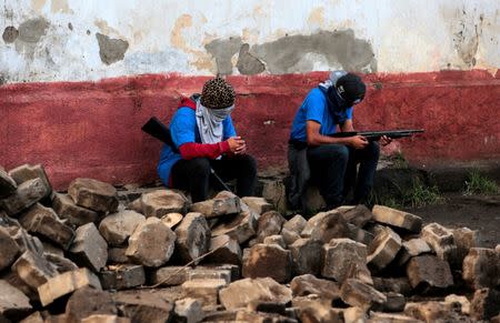 Pro-government supporters sit in a barricade after clashes with demonstrators in the indigenous community of Monimbo in Masaya, Nicaragua, July 17. REUTERS/Oswaldo Rivas