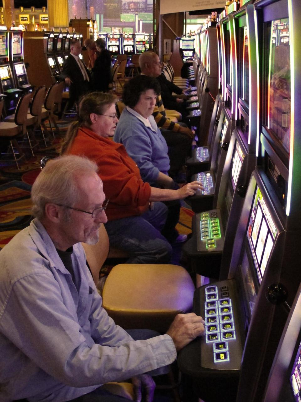Area resident Jerry Franklin, bottom left, celebrates his 56th birthday by joining other gamblers at the slot machines as the Hollywood Casino Columbus opens on Monday Oct. 8, 2012, in Columbus, Ohio. The $400 million Hollywood Casino Columbus is expected to draw 3 million visitors annually. (AP Photo/Kantele Franko.)