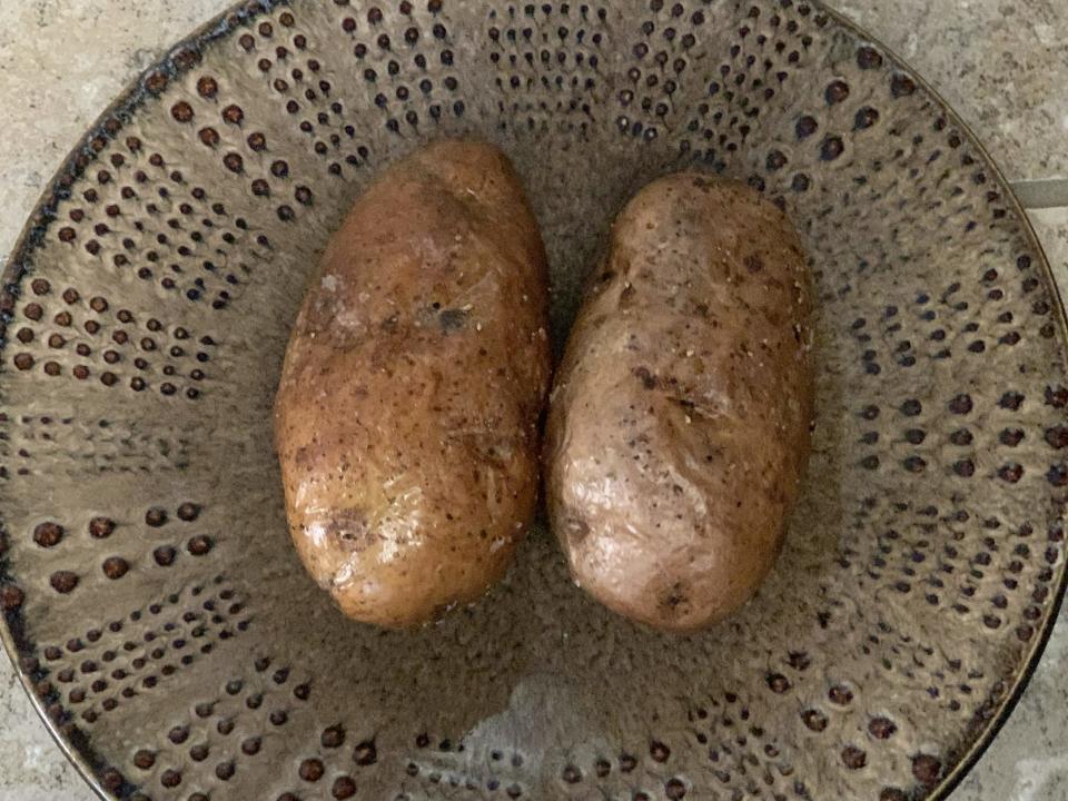 Two potatoes on a brown plate