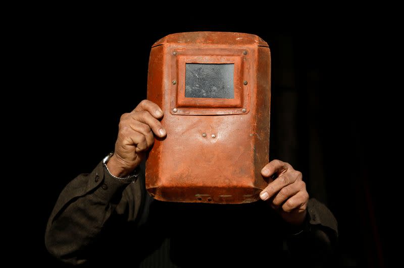 A man uses a welding helmet as he observes a solar eclipse in Peshawar