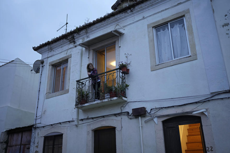 Georgina Simoes stands on the balcony of her rented apartment in Lisbon, Friday, March 10, 2023. The 57-year-old nursing home carer earns less than 800 euros ($845) a month, as do about a fourth of the country's workforce. For the last decade, she got by because she’s been paying just 300 euros a month for her one-bedroom apartment in an undistinguished Lisbon neighborhood. (AP Photo/Armando Franca)