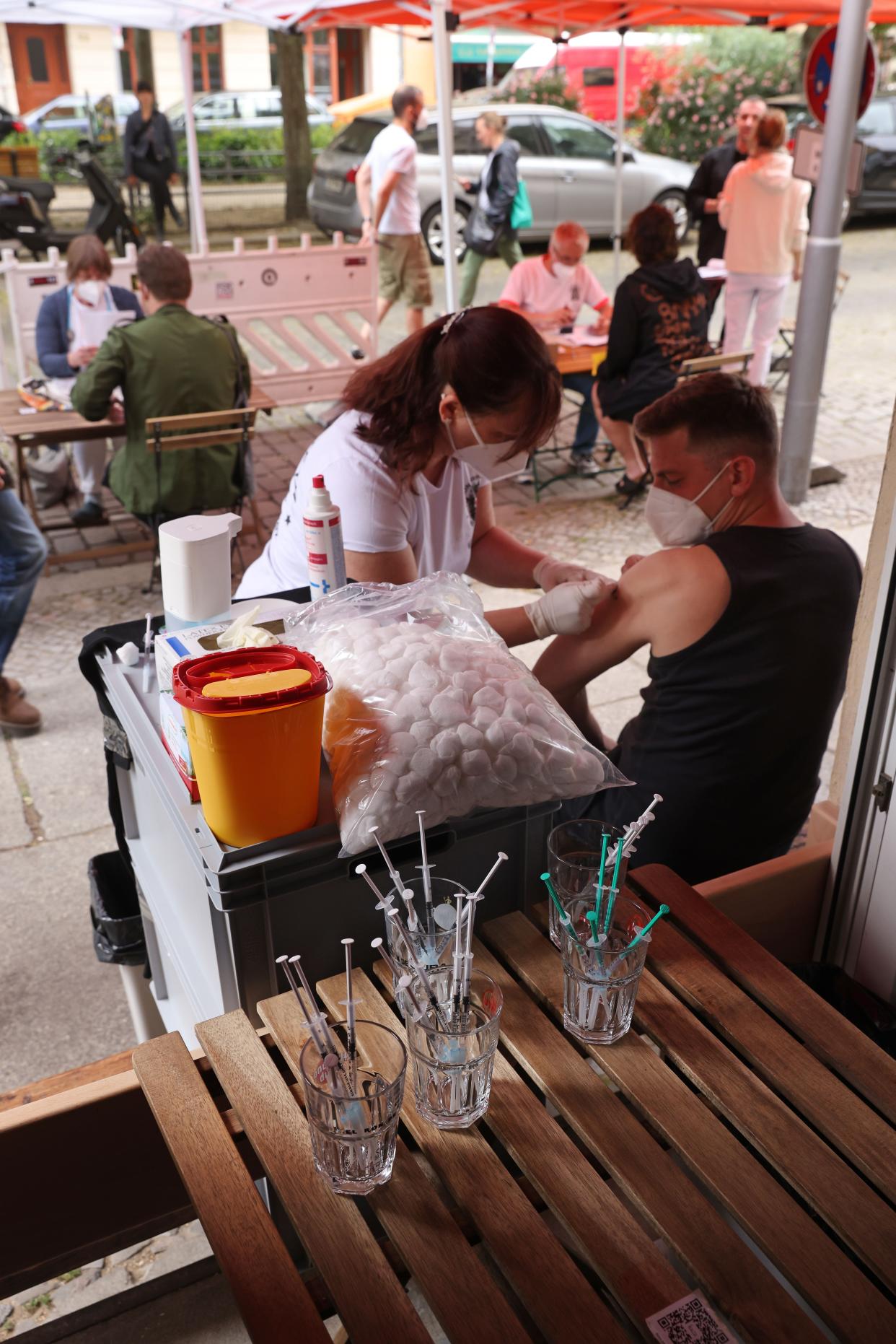 A medical assistant inoculates a man with the Johnson and Johnson Janssen vaccine against COVID-19 as arriving patients consult with doctors prior to their shots during a local vaccination drive at the Revolte Bar in Friedrichshain district on June 13, 2021, in Berlin, Germany. While mass vaccination centers across Germany are administering inoculations at a record pace, many communities have also launched local vaccination drives. Nearly 50% of the population in Germany has so far received a first vaccination dose and coronavirus infection rates have plummeted.