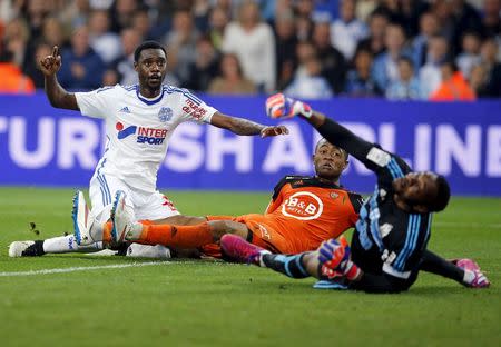 Lorient's Jordan Ayew (C) scores a goal against Olympique Marseille's goalkeeper Steve Mandanda (R) during their French Ligue 1 soccer match at the Velodrome stadium in Marseille, France, April 24, 2015. REUTERS/Jean-Paul Pelissier