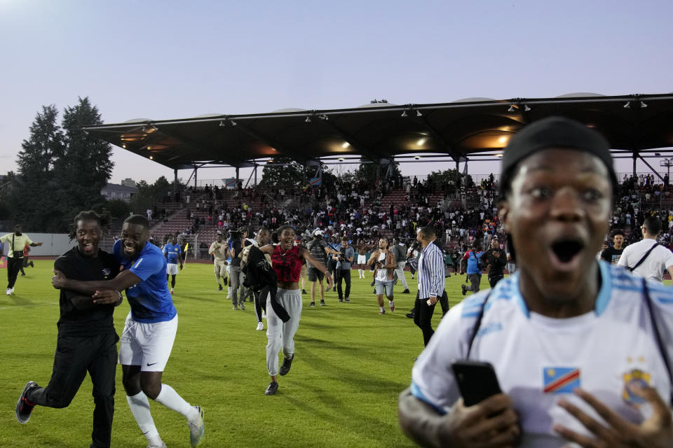 Congolese fans enter the pitch after Congo defeated Mali during the final game of the national cup of working-class neighborhoods betwwen a team representing players with Malian heritage against one with Congolese roots, in Creteil, outside Paris, France, Saturday, July 2, 2022. This amateur tournament aims to celebrate the diversity of youth from low-income communities with high immigrant populations, areas long stigmatized by some observers and politicians as a breeding ground for crime, riots, and Islamic extremism. (AP Photo/ Christophe Ena)