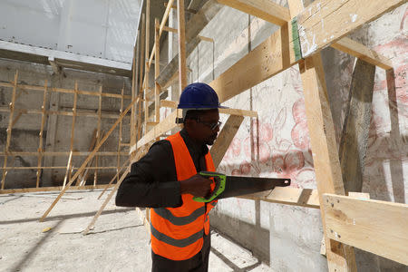 A construction worker uses a saw during the renovation project of Somalia's National Theatre in Mogadishu, Somalia February 3, 2019. Picture taken February 3, 2019. REUTERS/Feisal Omar