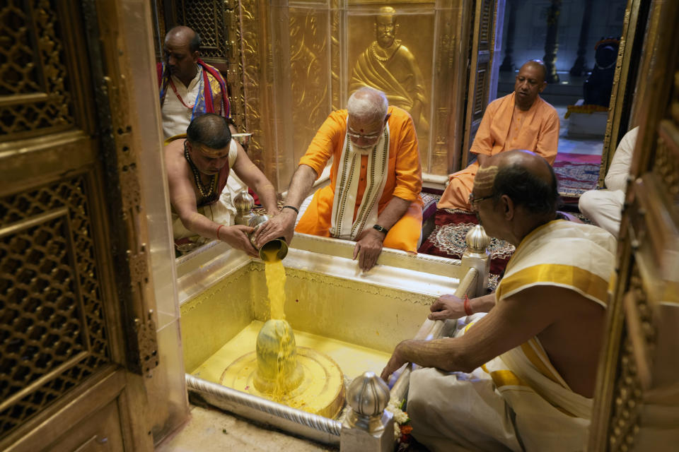Indian Prime Minister Narendra Modi, center, performs rituals at Kashi Vishwanath Temple as Yogi Adityanath, Chief Minister of Uttar Pradesh sits behind him after a roadshow in Varanasi, India, Monday, May 13, 2024. (AP Photo/Rajesh Kumar)