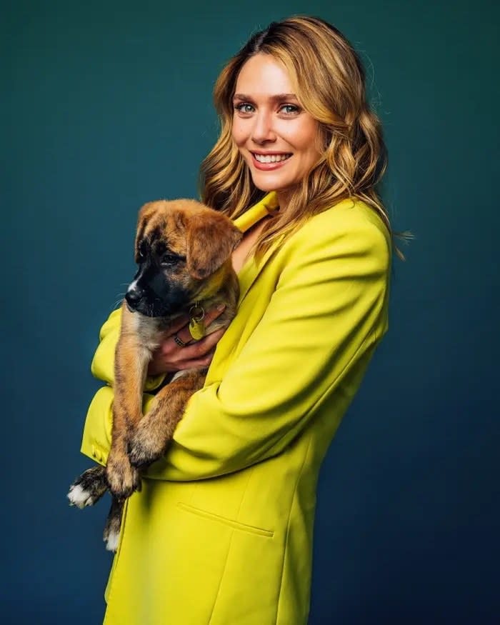 Elizabeth smiling and holding a puppy