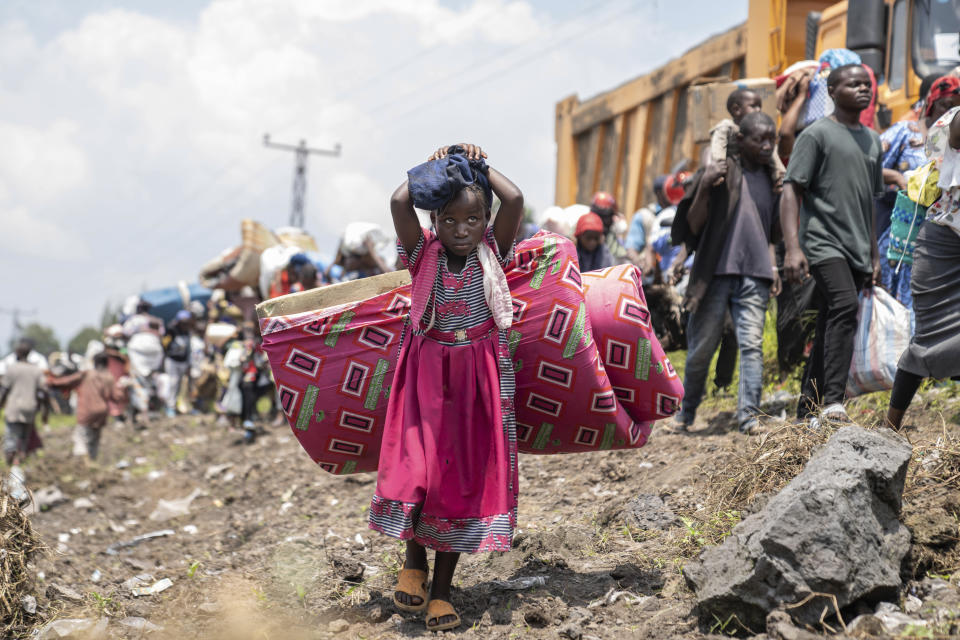 Thousands who are fleeing the ongoing conflict between government forces and M-23 rebels reach the entrance the Democratic Republic of Congo eastern city of Goma Wednesday, Feb. 7, 2024. (AP Photo/Moses Sawasawa)