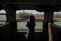 A woman looks out of a window from of a train traveling through the outskirts of Damascus towards recently opened international fair in Damascus, Syria, September 15, 2018. REUTERS/Marko Djurica/Files