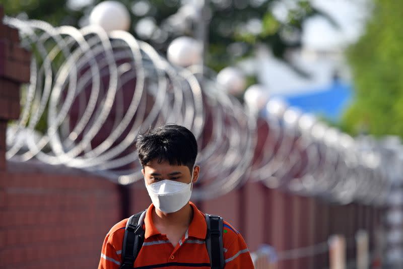 A man walks next to barbwire at the Crown Property Bureau in Bangkok